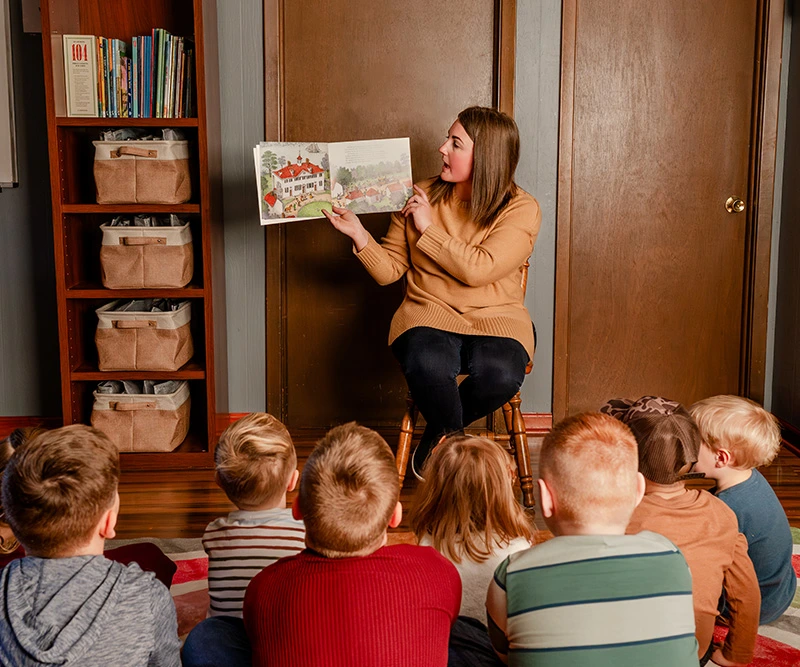 Teacher-showing-book-with-children